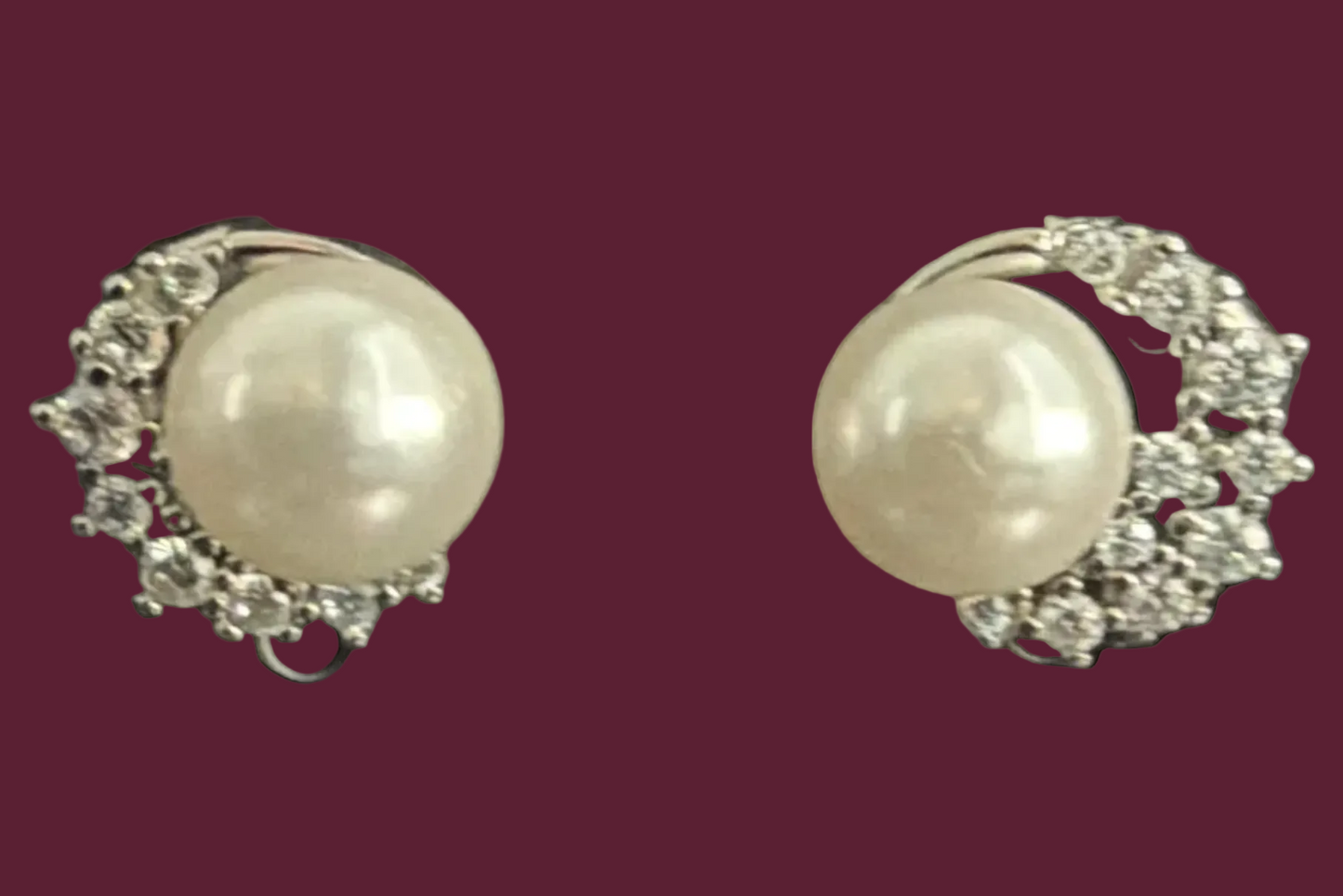 Pair of pearl earrings with silver accents on a black background