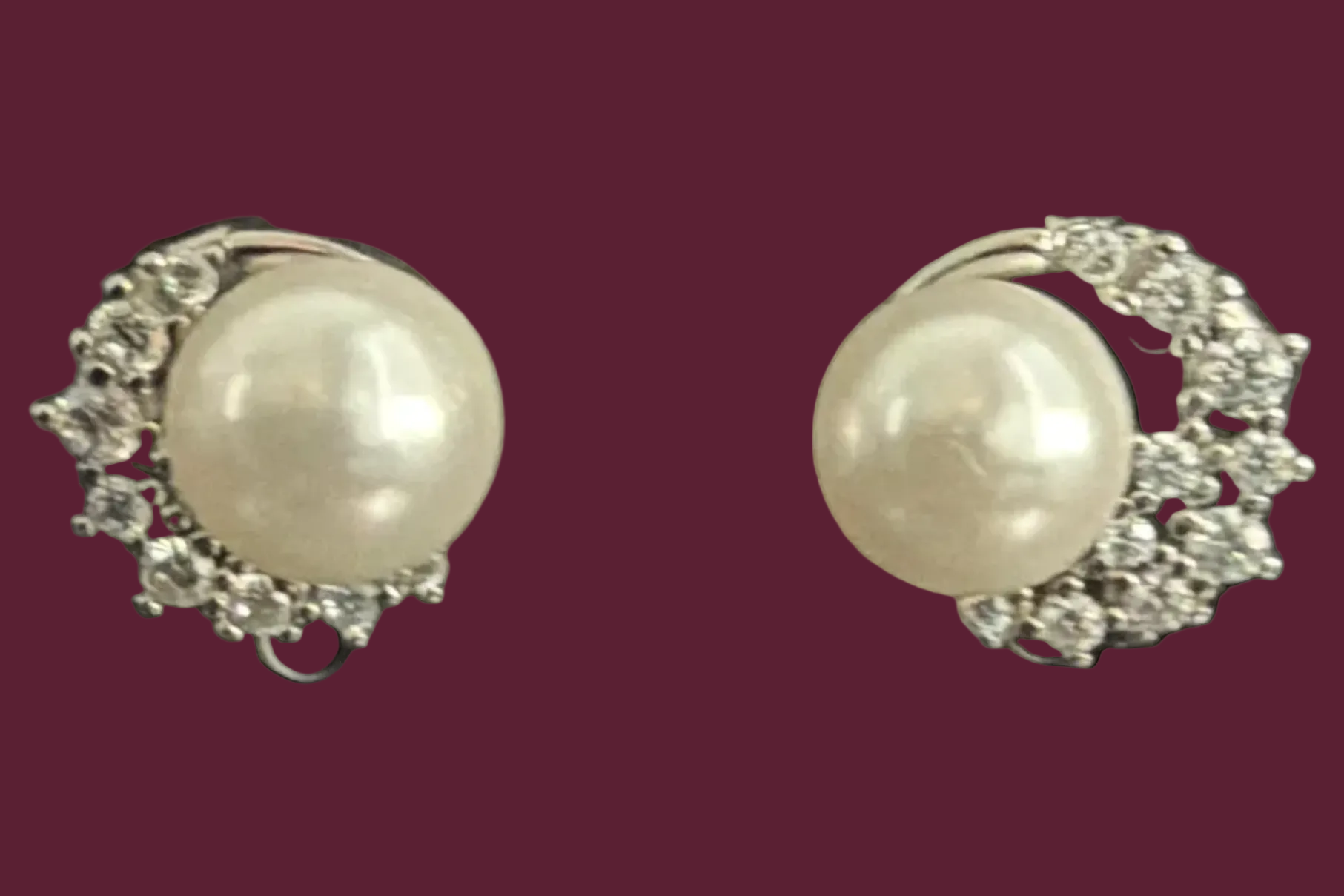 Pair of pearl earrings with silver accents on a black background